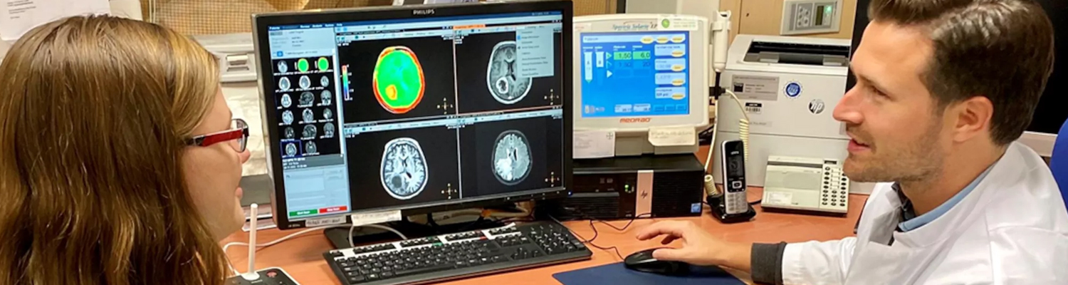 Privatdozent Dr. Daniel Paech und die Doktorandin Inga Krause diskutieren MRT-Aufnahmen eines Patienten mit Hirntumor.